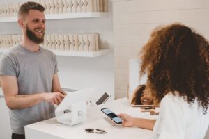Australian small business owner at shop counter working on laptop